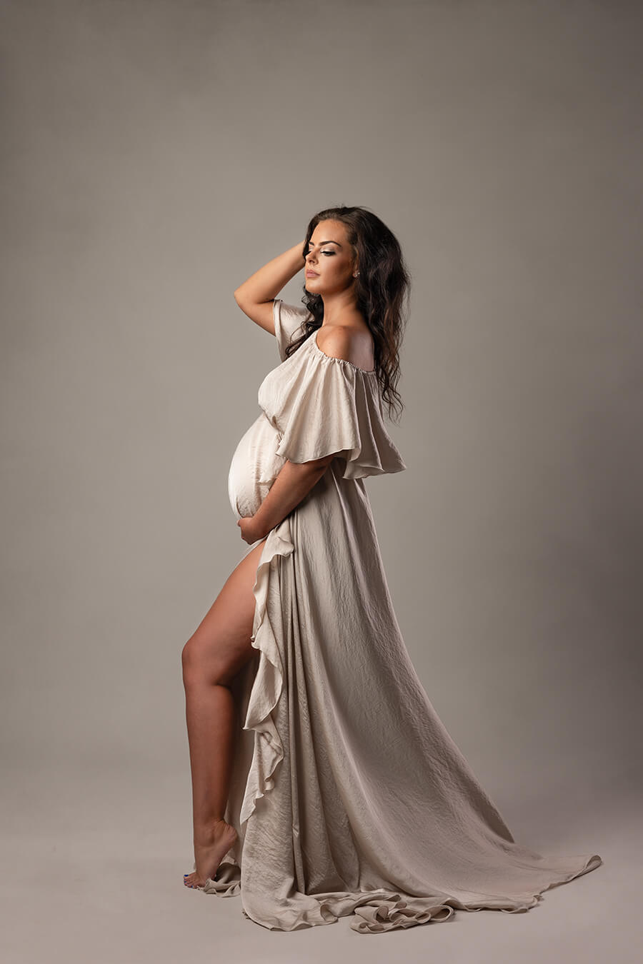 long silky sand dress featuring an off shoulder neckline and a split on the long skirt