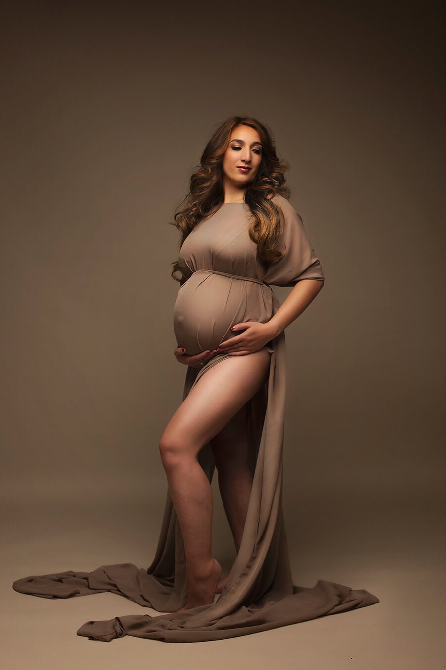 pregnant model wearing a long chiffon cape in espresso color. 