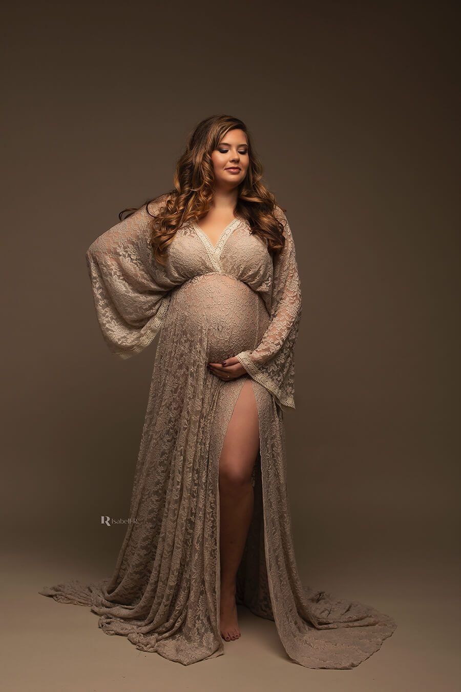 The boho styled dress has a split at the front by her leg. The color of the dress is sand and is has a low v cut neckline