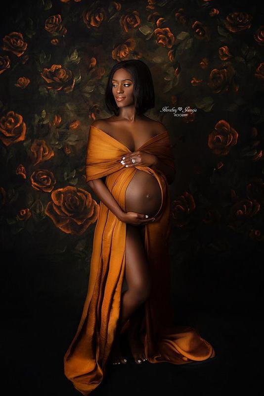 model with short dark hair poses with a cognac scarf wrapped around her arms and with an uncovered belly.