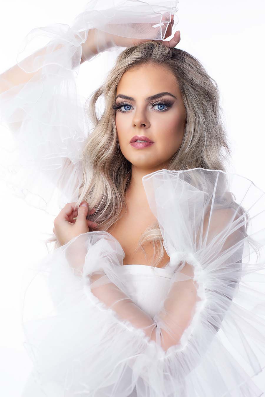close up from a blond model wearing tulle sleeves in off white.