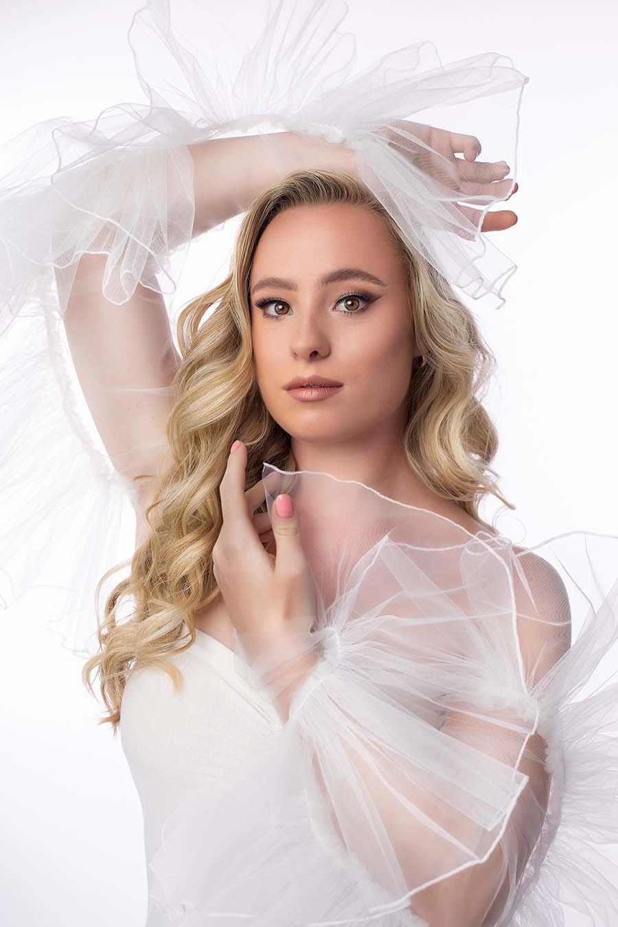 close up from a blond model wearing tulle sleeves in off white.
