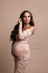 This long off the sholder dress is made out of lace . The model has long brown hair and she is pregnant