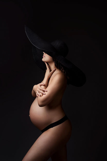 The pregnant woman is posing inside a photography studio. You can&