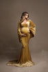This model is standing in a studio with fake smoke around her. She is wearing a tight vevlet dress in the colour yellow amber. The sleeves are wide and flowy 