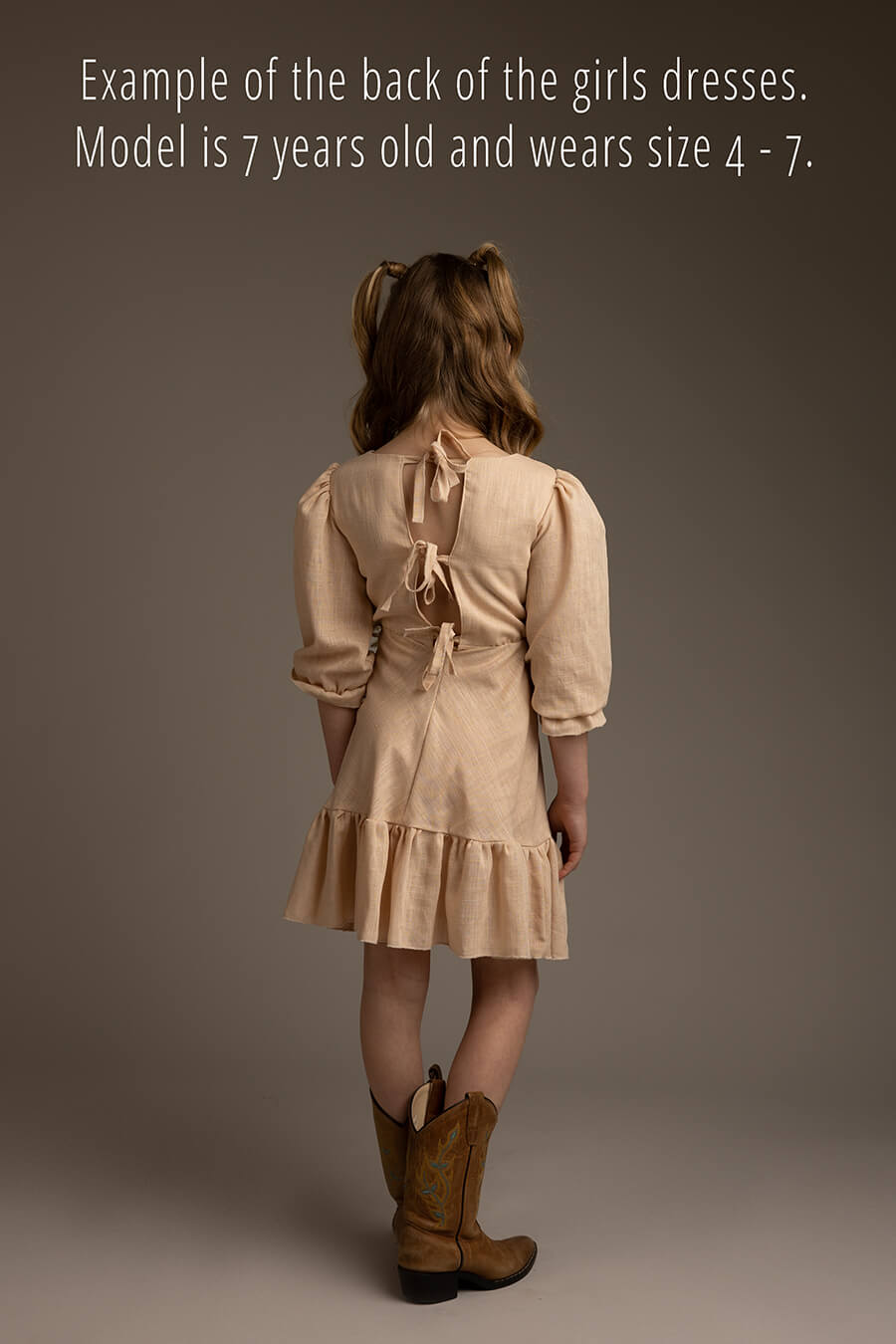photo of the back of the girls dress. bows can be used to adjust the sizing of the dress.