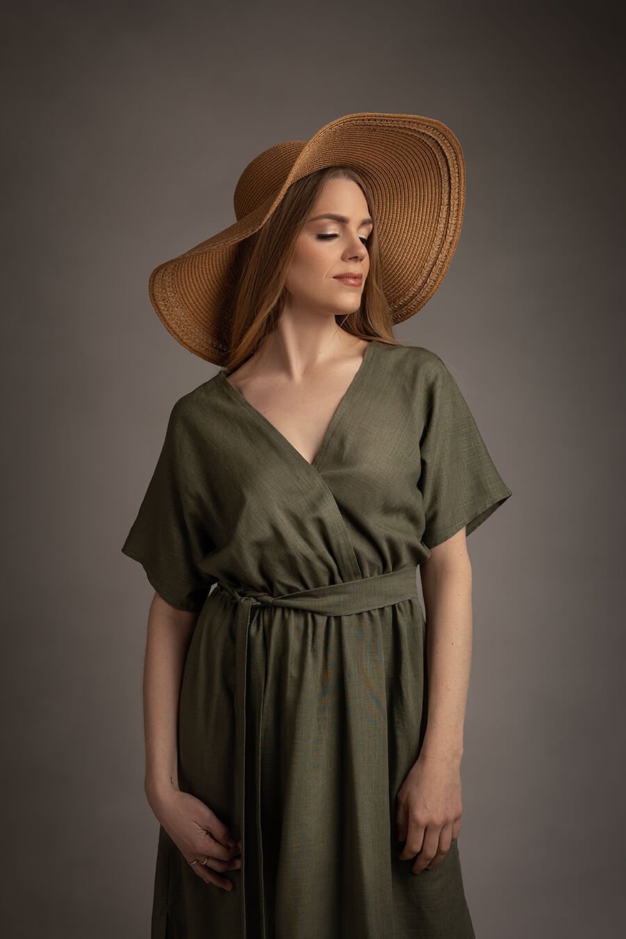 close up of a blond model posing in a studio during a boho western chic photoshoot. she has her eyes closed and wears a brown hat to match the style.