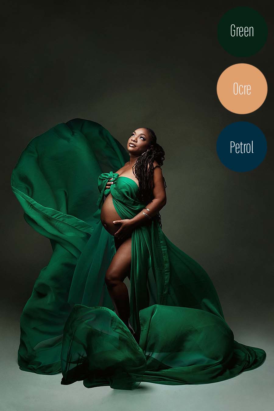 pregnant model poses in a studio wearing a dark green voile scarf with a knot tight on her chest and leaving her belly uncovered.