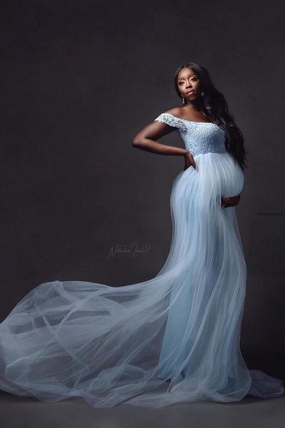 model poses in a studio wearing a light blue long dress made of lace and tulle. the dress isnt see through.
