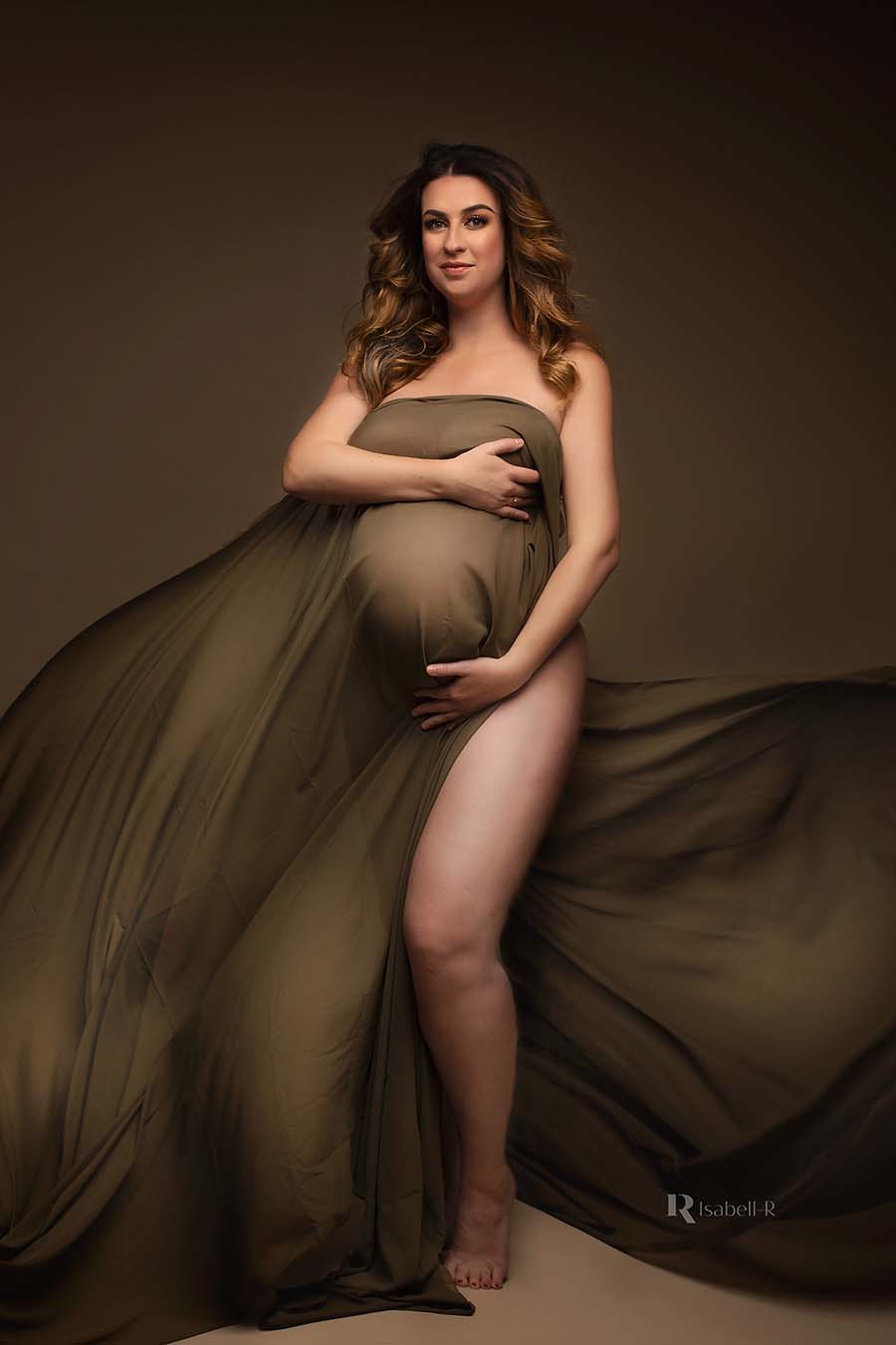A tall model is wraped in a scarf. The scarf is a little bit see trough and creates beautiful wave effects. The model is pregnant