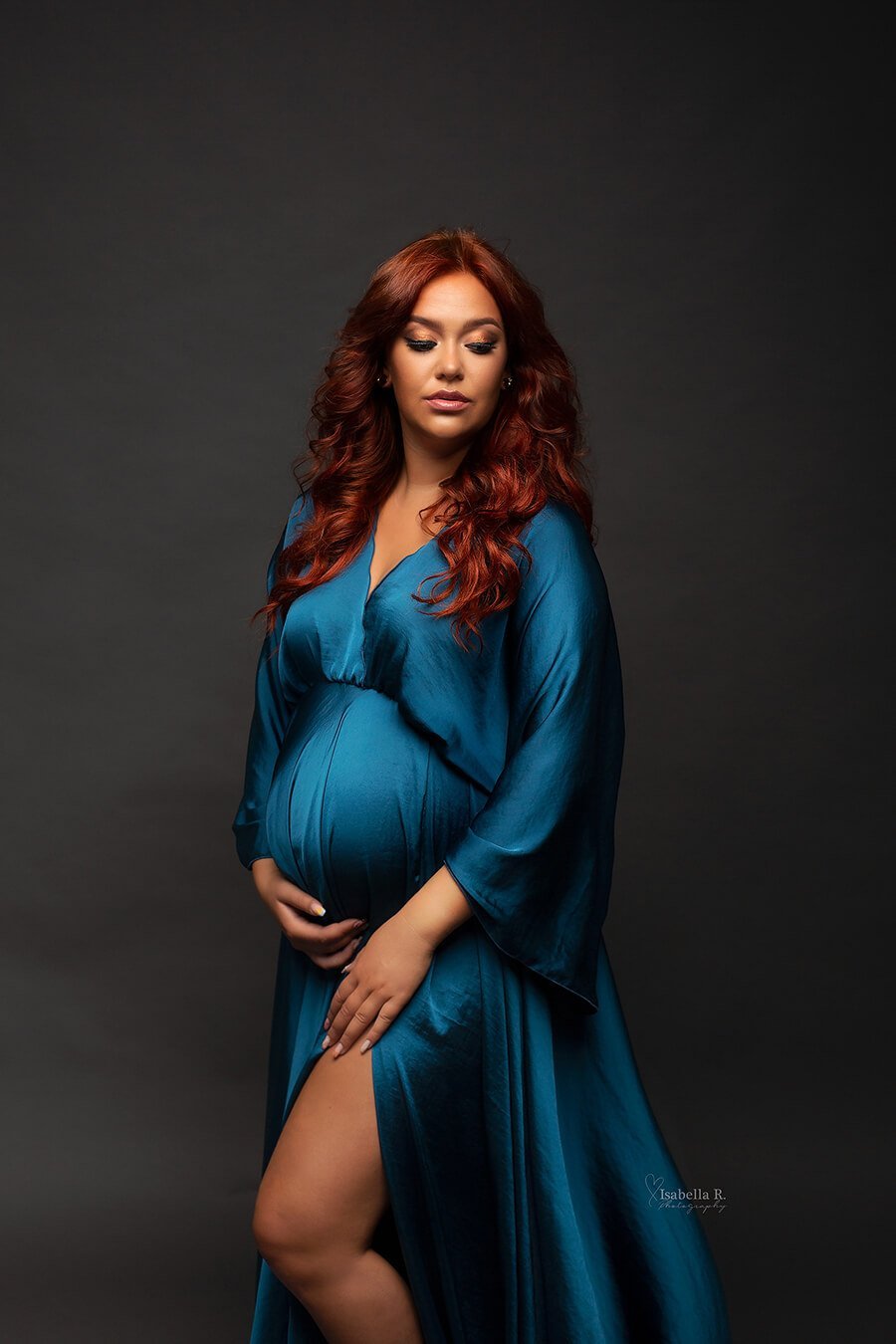 A woman with long red hair is wearing a blue Boho styled dress. The dress has long sleeves 