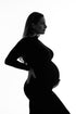 black and white profile photo of a pregnant model wearing a long tight dress in black color. 