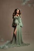Dark blond pregnant model poses in a studio during a maternity photoshoot wearing a jersey dress designed by Mii-Estilo. The dress features a sweetheart top and bell sleeves. The dress has a split on the side where you can see a bit of the model&