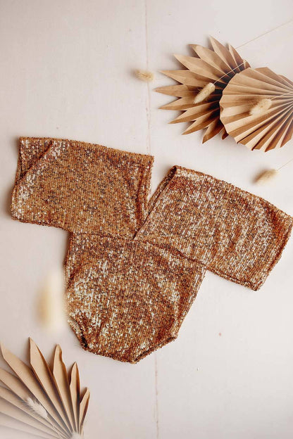 This is a product photo of the holly romper gold. The romper has gold sequins on it and boho sleeves.