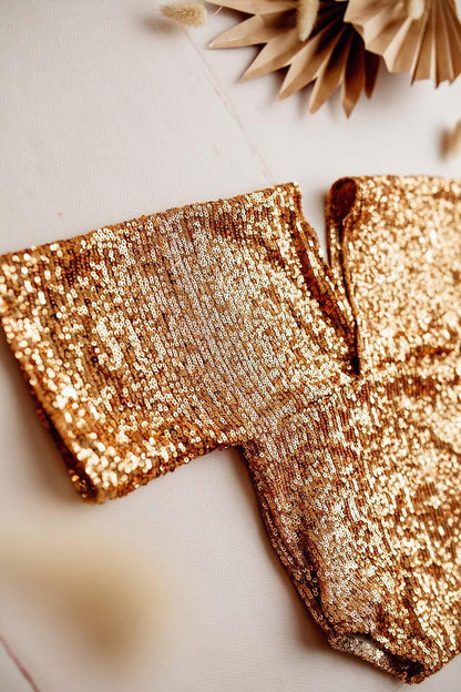 This is a close up photograph of holly romper gold. Product photo