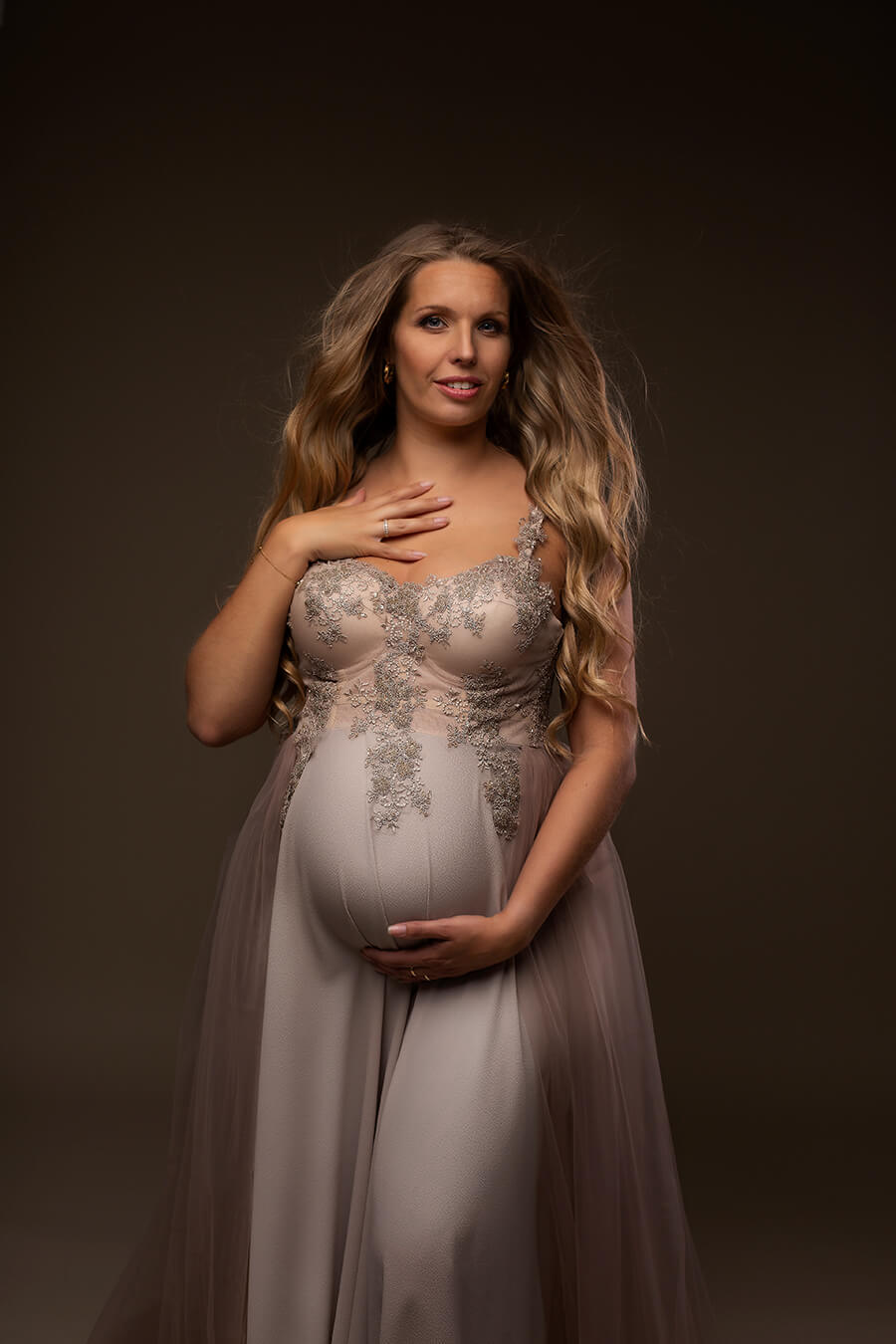 Blond pregnant model poses in a studio during a maternity photoshoot wearing one of mii-estilo&
