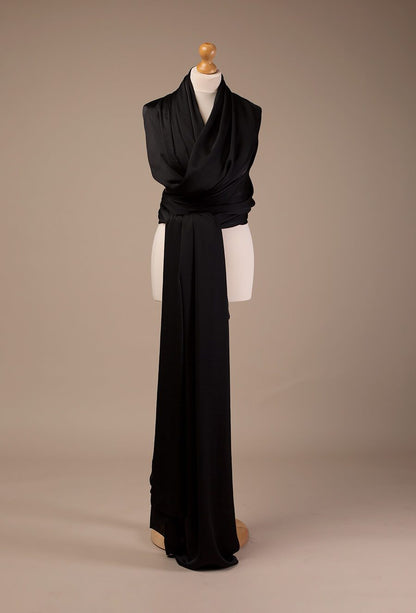 a black scarf on a stand. It is wrapped around it to make it look like a dress