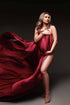 A pregnant model is being covered up with a scarf. She is holding the fabric. The rest of the fabric is waving next to her for a nice effect. The fabric is silk and the color is cherry. 