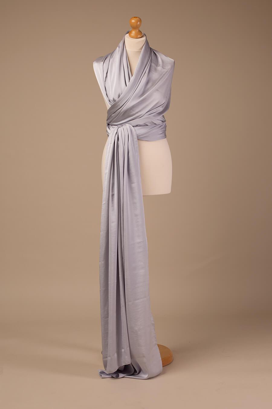 This is a product photo of the silky scarf cool grey. The scarf is hanging on a mannequin.