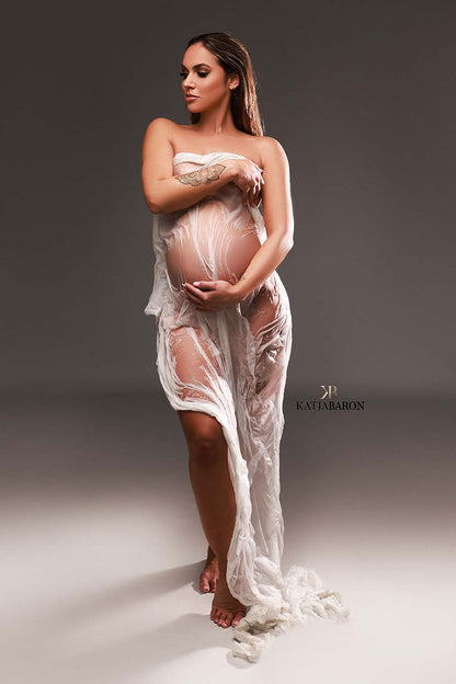 pregnant model poses with a white wet silky scarf covering her body.