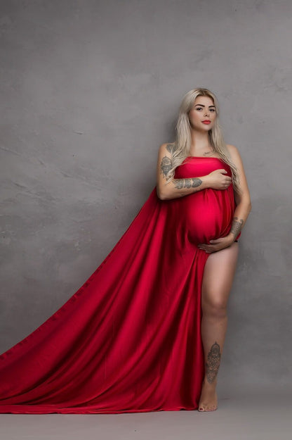 Blond model covers her breasts and belly with a long red silky scarf.