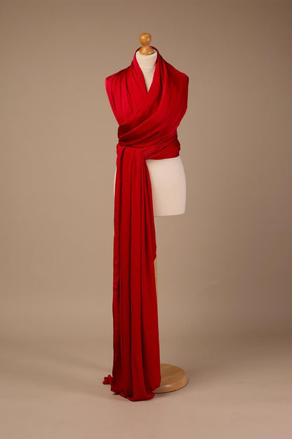 Photo display from a long red silky scarf in a studio.