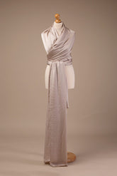 Picture of a draping shimmery piece of fabric in sand color displayed in the studio. 