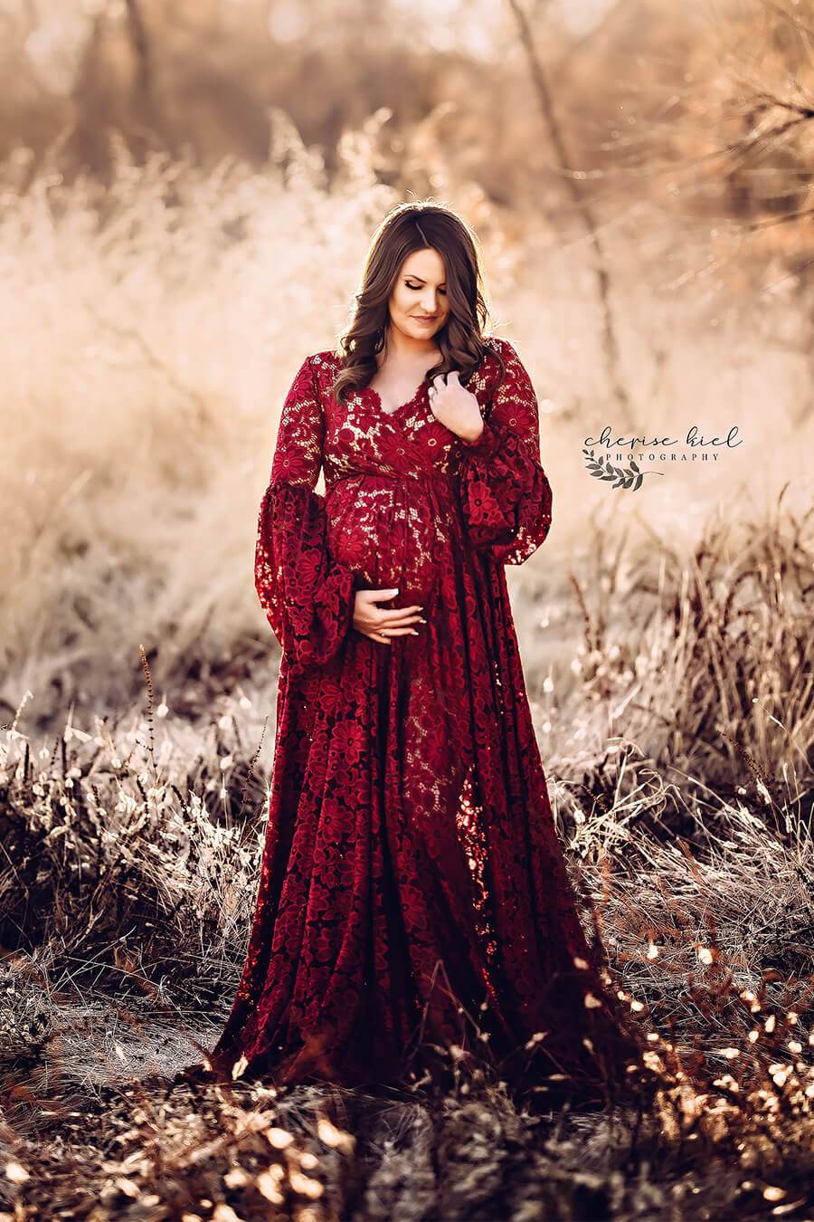 a maternity dress in the color bordeaux. The dress is worn be a maternity model with brown hair. The dress is from lace 